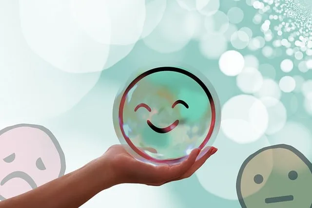 Main tenant une bulle illustrée d'un visage souriant, sur fond verdoyant