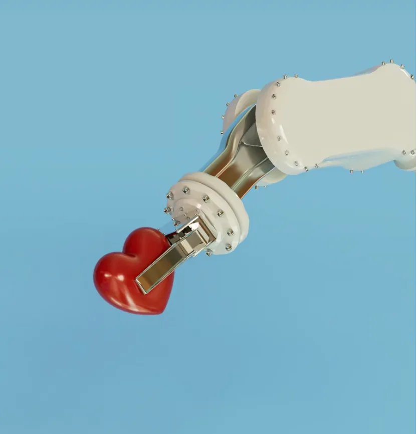 Cœur rouge tenu par une pince robotique blanche sur fond bleu